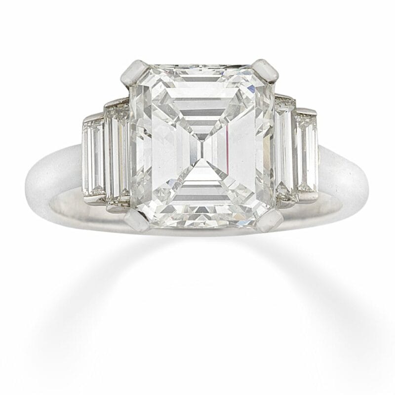An Emerald-cut Diamond Ring With Diamond-set Shoulders