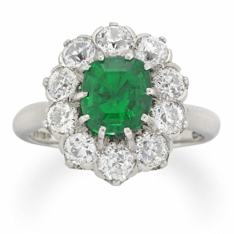 An Oval Emerald And Diamond Cluster Ring