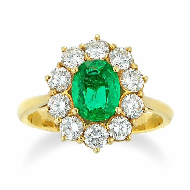 An Oval Emerald And Diamond Cluster Ring