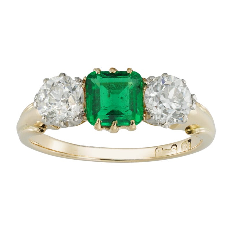 An early 20th century three stone emerald and diamond ring
