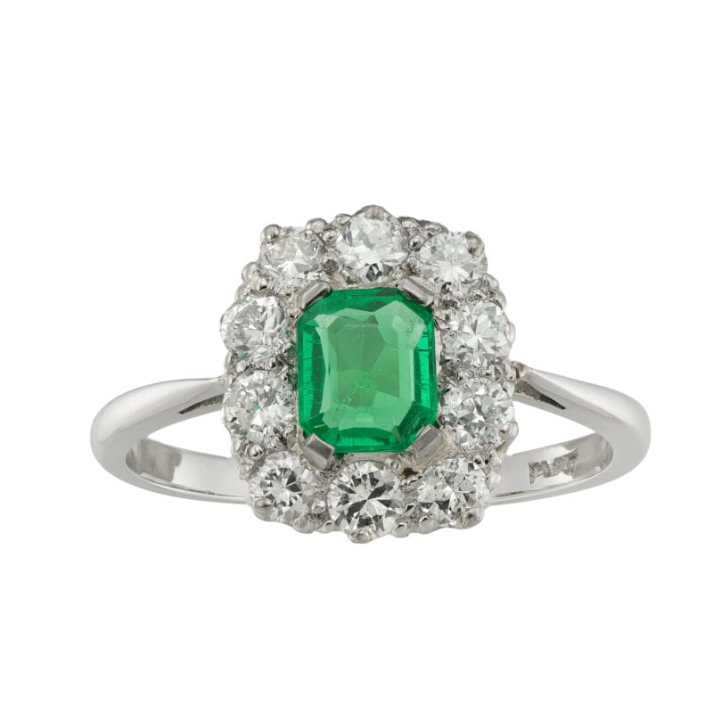 An emerald and diamond cluster ring